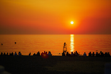 Fototapeta premium People enjoying sunset on the beach of Mers-les-Bains, France