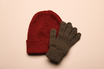 Warm hat and gloves on color background
