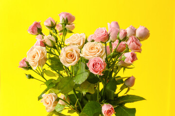 Bouquet of beautiful roses on yellow background