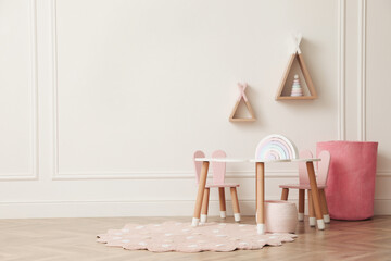Cute child room interior with furniture, toys and wigwam shaped shelves on white wall. Space for text © New Africa