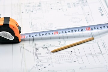 Lápiz y flexómetro en lo alto de un plano de arquitectura