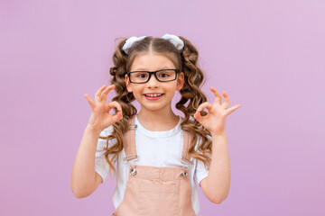 the curly-haired girl shows the ok sign and smiles. child on an isolated background.