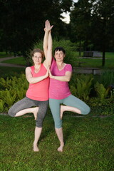 2 Frauen machen Yoga im Park aneinander