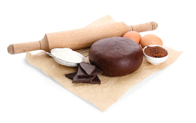 Baking parchment with ingredients for preparing tasty cookies and rolling pin on white background