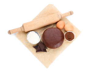 Baking parchment with ingredients for preparing tasty cookies and rolling pin on white background