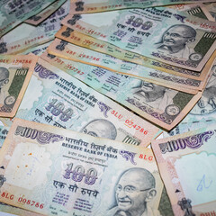 Old One Hundred Rupee notes combined on the table, India money on the rotating table. Old Indian Currency notes on a rotating table, Indian Currency on the table