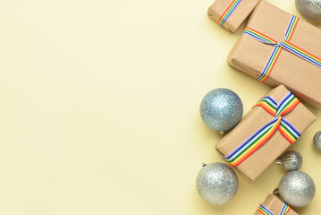 Gift boxes with rainbow LGBT ribbons and Christmas balls on beige background