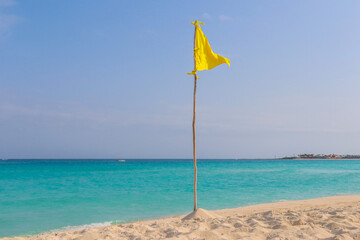 Yellow flag during a beautiful day at the beach in Cancun. 