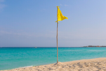 Yellow flag during a beautiful day at the beach in Cancun. 