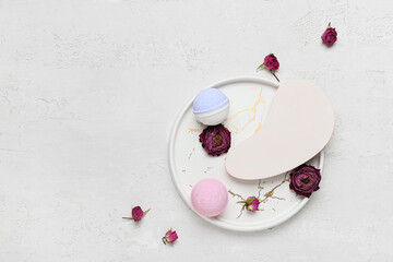 Composition with bath bombs and dried rose flowers on light background