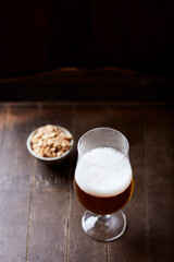 Glass of beer on dark wooden background. Copy space. 