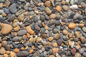 Beautiful texture of colorful smooth stones is on the beach by sea