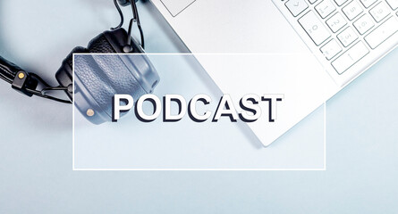 Podcast word. Photo with headphones and laptop.