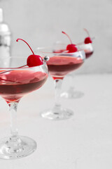Glasses of tasty Manhattan cocktail on light background, closeup