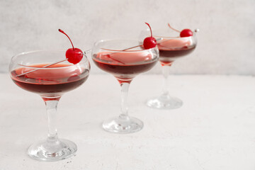 Glasses of tasty Manhattan cocktail on light background
