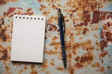 notatnik i długopis  na zardzewiałej blasze 