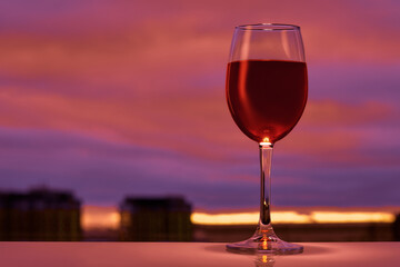 A glass of red wine at sunset in the bar.
