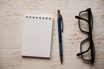 notatnik , długopis i okulary na drewnianym stole - obrazy, fototapety, plakaty