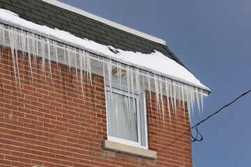 Ice forming on the edge of a house roof 