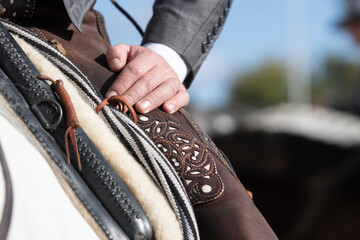 Detail of the hand of a rider and his Zahon in the traditional doma vaquera