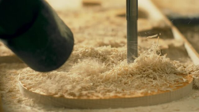 CNC machine bit cutting wooden stock and vacuum cleaner removing dust, macro slow motion shot