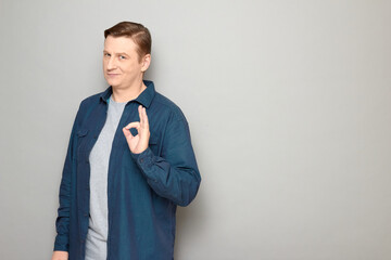 Portrait of confident mature man showing okay gesture and smiling