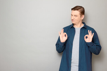 Portrait of confident mature man showing okay gestures and smiling