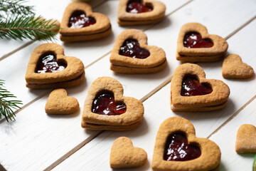 Sweet dessert for a family snack: Cookies with jam in the shape of a heart on a white background. Close-up.