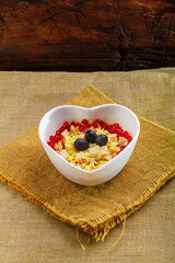 Puff salad with chicken breast, garnished with pomegranate and olives in a salad bowl on a napkin.