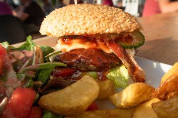 Potato wedges, lettuce and cheeseburger close-up