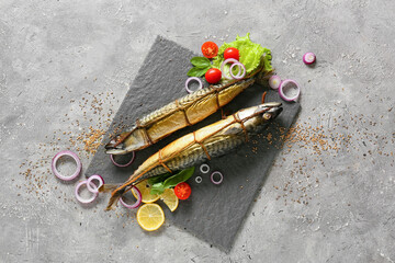 Fototapeta na wymiar Board with smoked mackerel fishes on grey background
