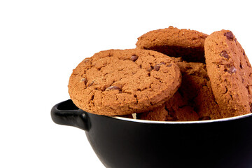 Cookies with cocoa and chocolate chips in a black plate close-up on a white background