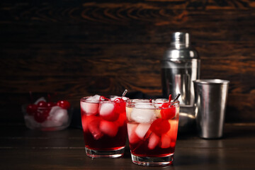 Glasses of tasty Manhattan cocktail on dark wooden background