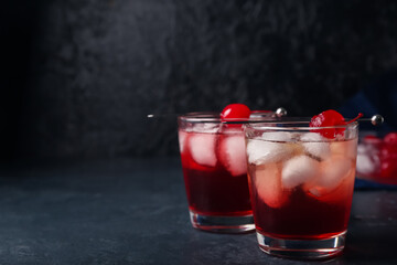 Glasses of tasty Manhattan cocktail on black background