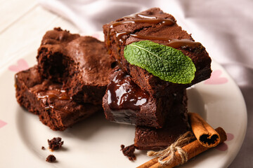 Plate with pieces of tasty chocolate brownie on table, closeup
