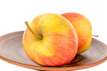 Two red juicy apples on a clay plate, macro, isolated on white.