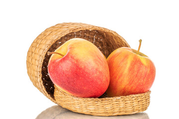 Two red juicy apples with a basket, macro, isolated on white.