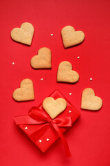 Tasty heart shaped cookies and gift box on red background. Valentines Day celebration