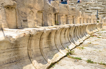 Stone seats of Theater of Dionysus near Acropolis, Athens, Greece. Marble chairs with owners names inscription.