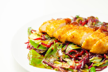Breaded crispy chicken breast fillet with mixed salad and grated beetroot
