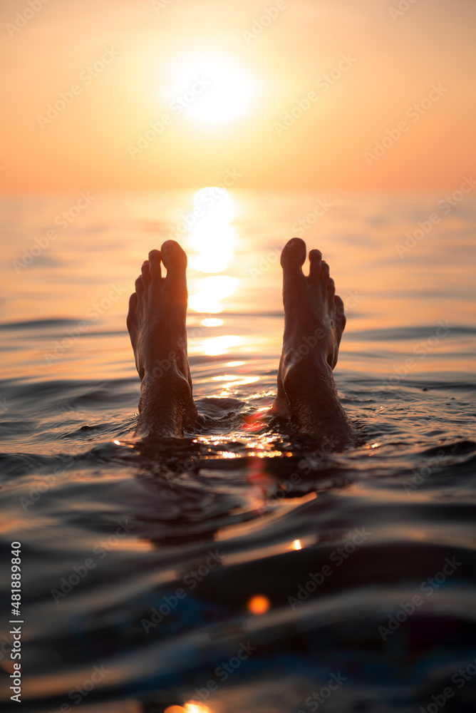 Wall mural feets in water sunset