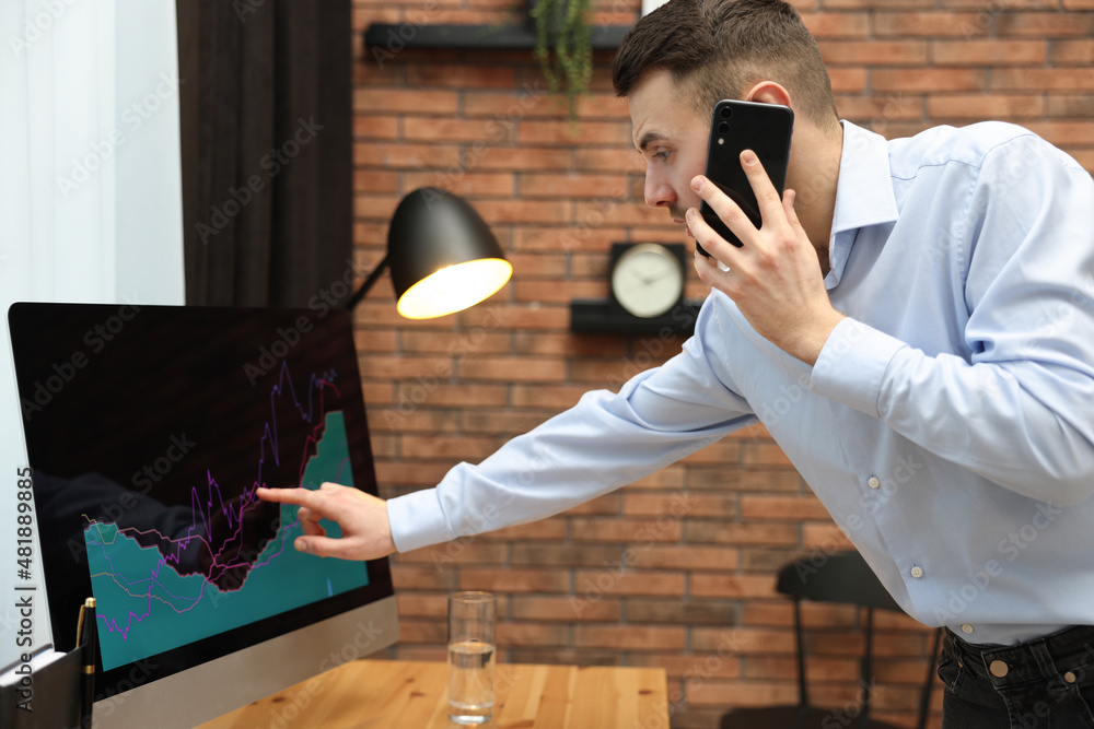 Poster forex trader talking on phone while working in office