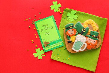 Composition with tasty gingerbread cookies for St. Patrick's Day celebration on red background