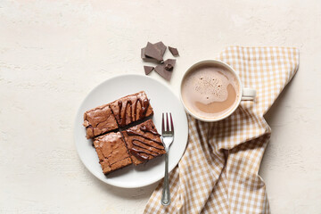 Plate with chocolate brownie pieces and cup of coffee on white background