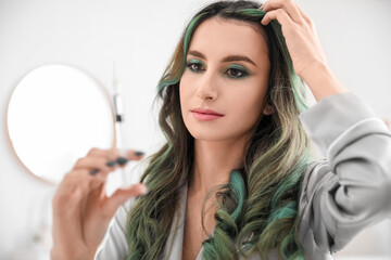 Fototapeta premium Young woman with hair loss problem holding syringe for regeneration injections at home