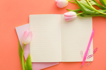 Composition with notebooks, tulips and pen on color background