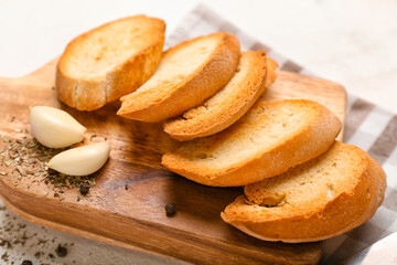 Wooden board with tasty croutons on table, closeup