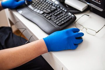 A doctor in blue gloves quickly collects data about a patient. The concept of healthcare and taking care of your health. Workplace of a doctor, online consultation.