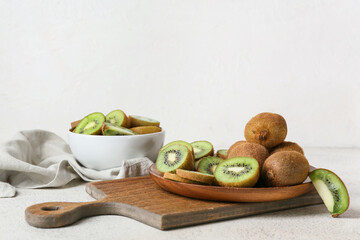 Plate with fresh cut kiwi on light background