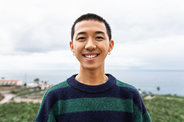 Portrait of happy young Asian teenager smiling in front of camera